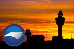 north-carolina map icon and an airport terminal and control tower at sunset