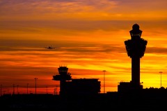 an airport terminal and control tower at sunset