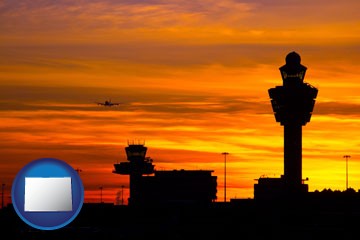 an airport terminal and control tower at sunset - with Colorado icon