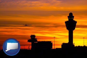 an airport terminal and control tower at sunset - with Connecticut icon