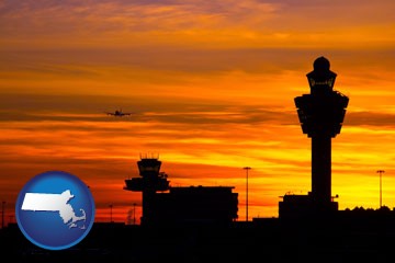 an airport terminal and control tower at sunset - with Massachusetts icon