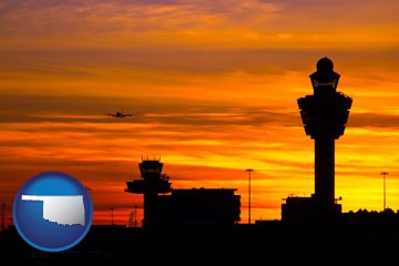 an airport terminal and control tower at sunset - with Oklahoma icon